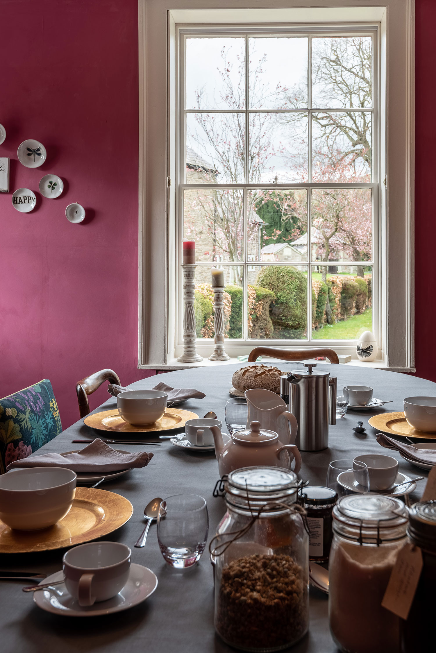 View of dining room table with window behind looking out on to the garden