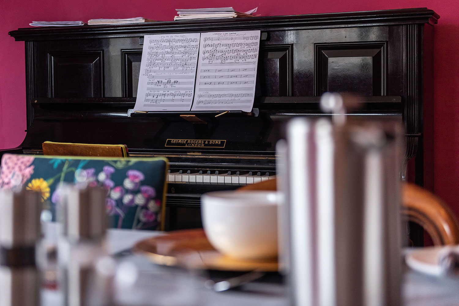 Dining room table with piano in background